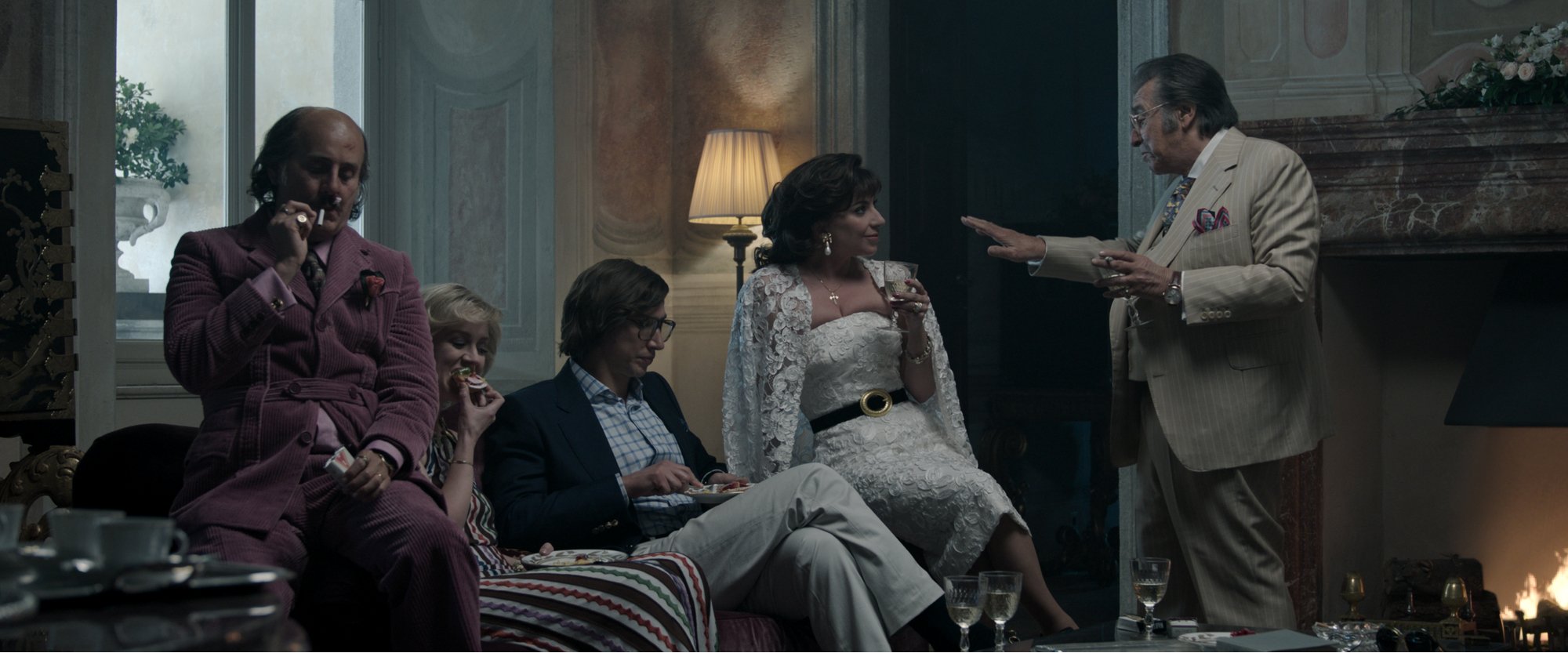 'House of Gucci' family members Jared Leto stars as Paolo Gucci, Florence Andrews as Jenny Gucci, Adam Driver as Maurizio Gucci, Lady Gaga as Patrizia Reggiani and Al Pacino as Aldo Gucci sitting around talking in front of the fireplace