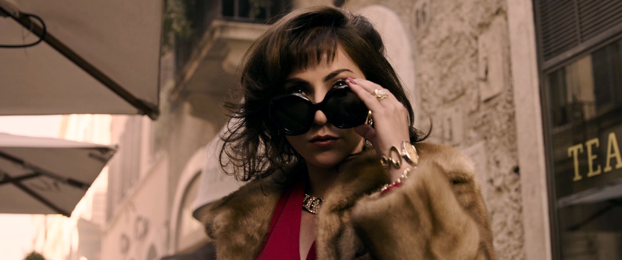 'House of Gucci' review star Lady Gaga as Patrizia Reggiani wearing a fur coat and lowering her sunglasses