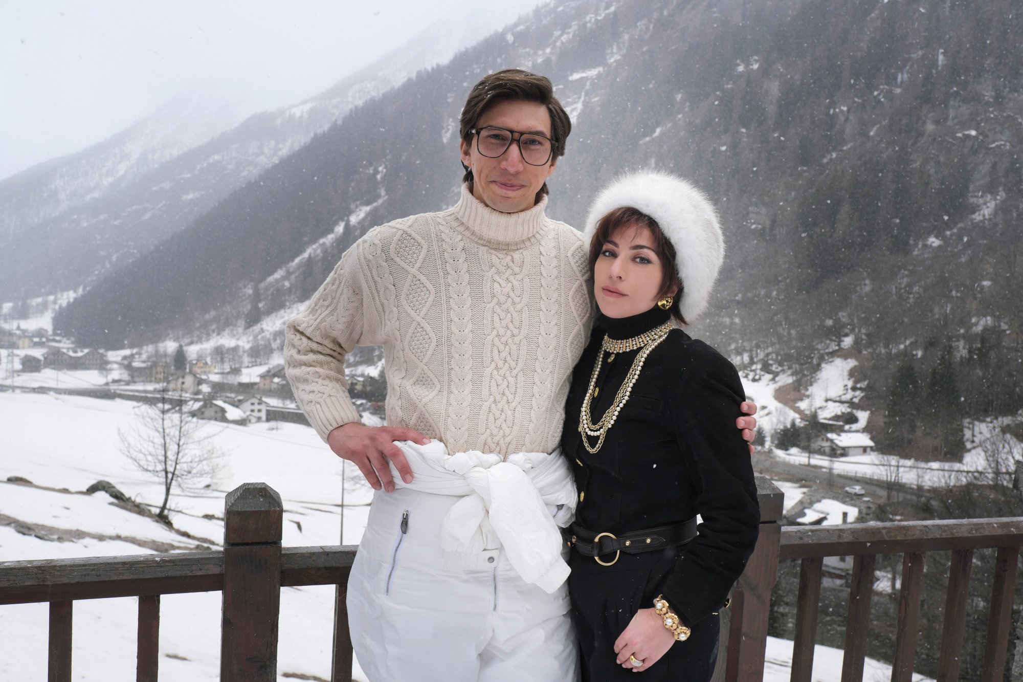由 Adam Driver 饰演 Maurizio Gucci 和 Lady Gaga 饰演 Patricia Reggiani 穿着雪衣和身后雪景的“古驰之家”的评论