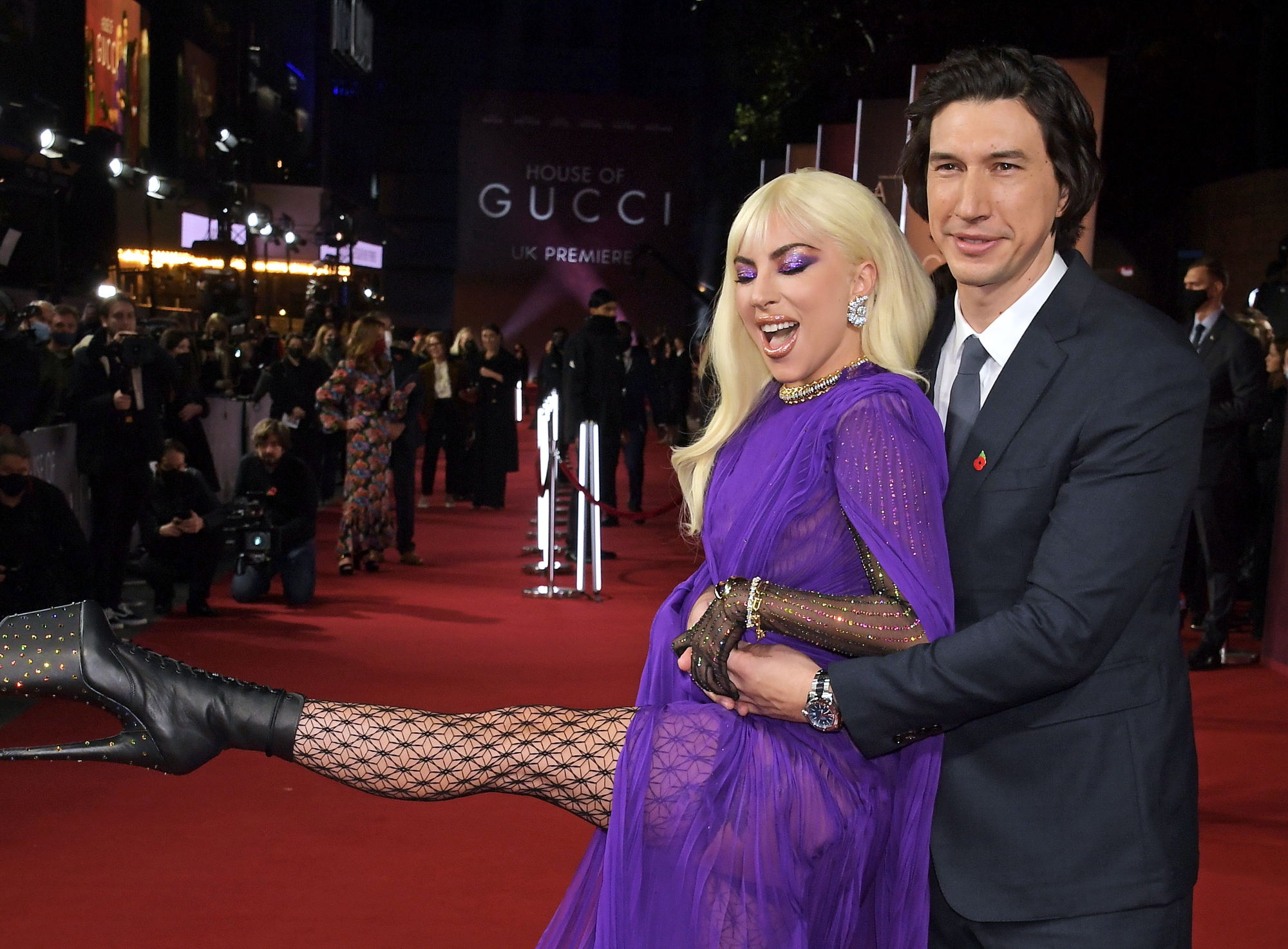 'House of Gucci' sex scene co-stars Lady Gaga and Adam Driver holding each other with Lady Gaga kicking her leg out