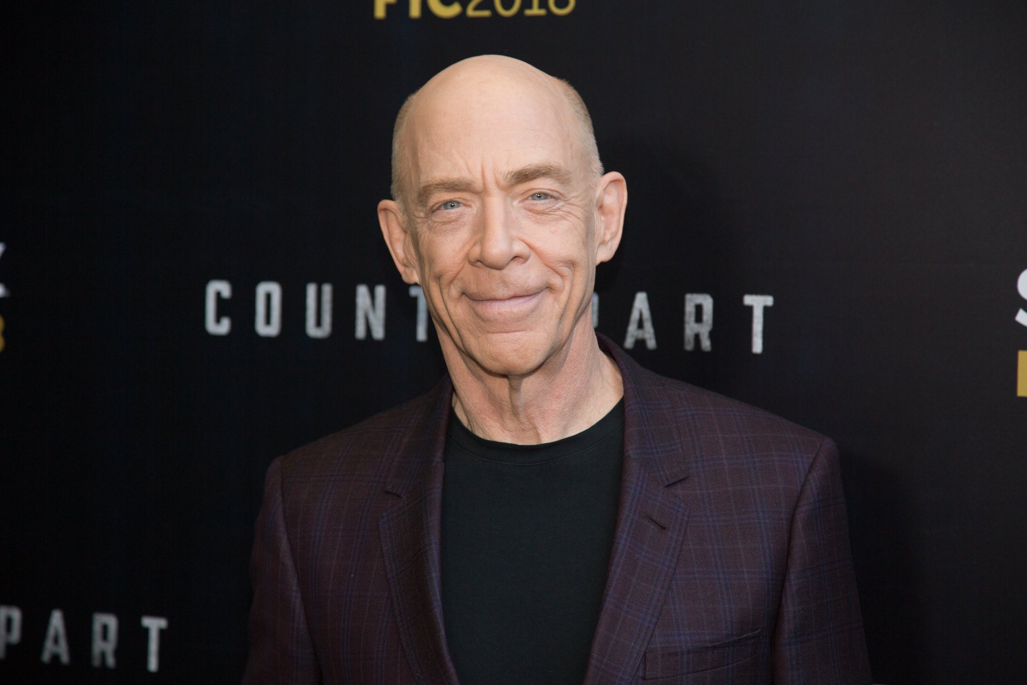 'Spider-Man' star J.K. Simmons, who plays J. Jonah Jameson in Sam Raimi's trilogy. He's wearing a dark shirt and jacket and smiling at the camera.