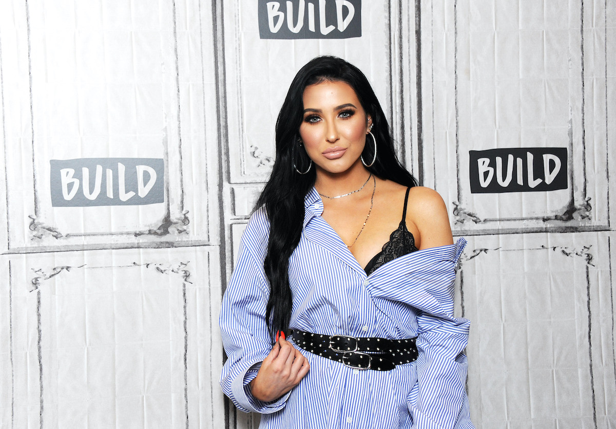 Jaclyn Hill wears nude lipstick and a blue shirt dress