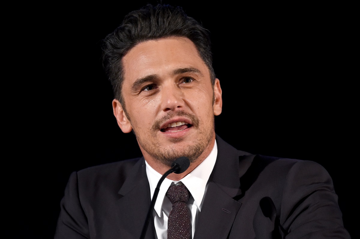 James Franco speaking on stage while wearin a suit
