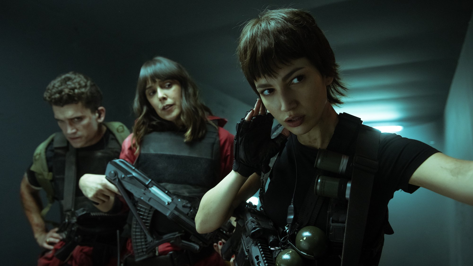Jamie Lorente, Belén Cuesta, and Úrsula Corberó dressed in red and black gear in Netflix's 'Money Heist.'
