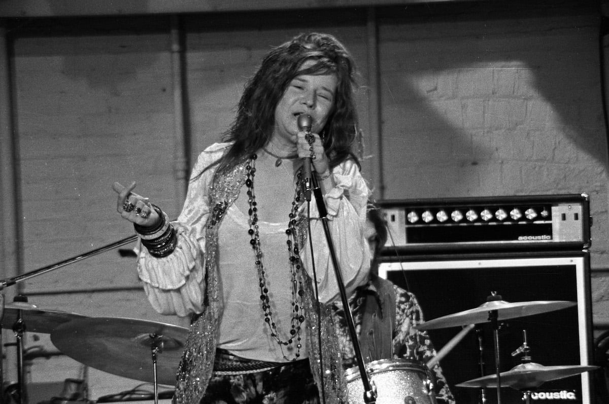 Janis Joplin sings into a microphone.