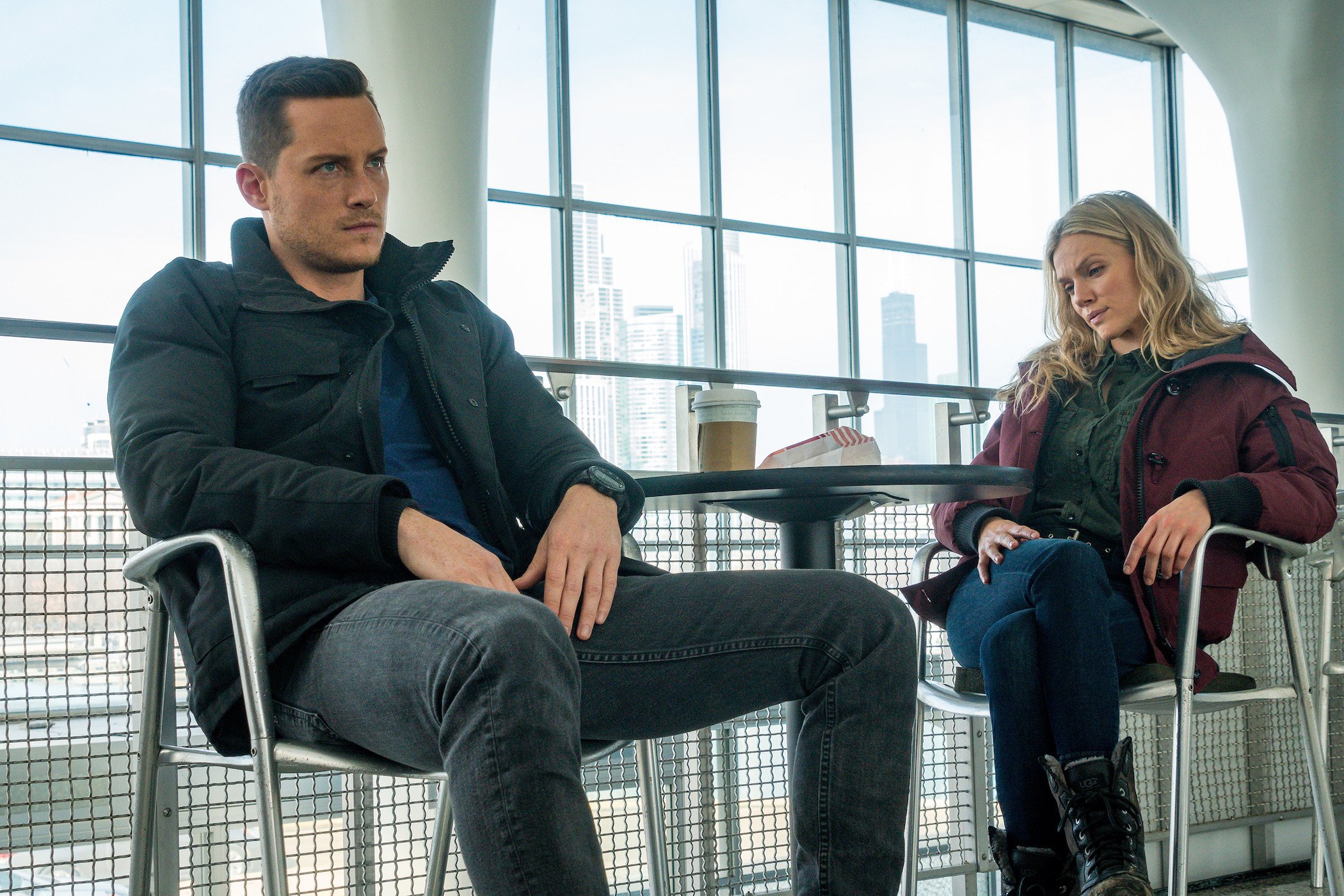 Jesse Lee Soffer as Jay Halstead and Tracy Spiridakos as Hailey Upton sitting near each other in chairs in 'Chicago P.D.'