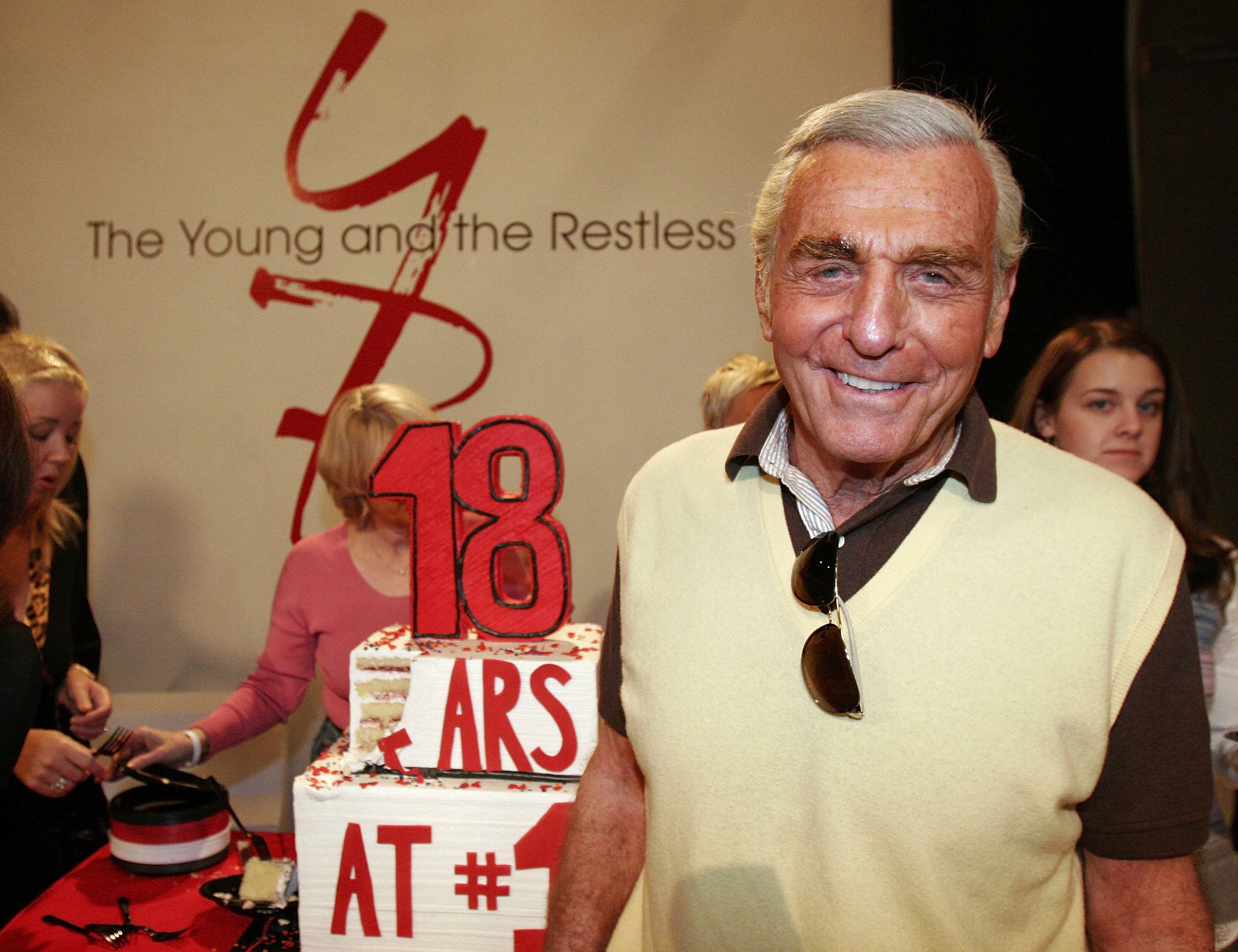 'The Young and the Restless' actor Jerry Douglas wearing a brown and white shirt, standing beside a cake.