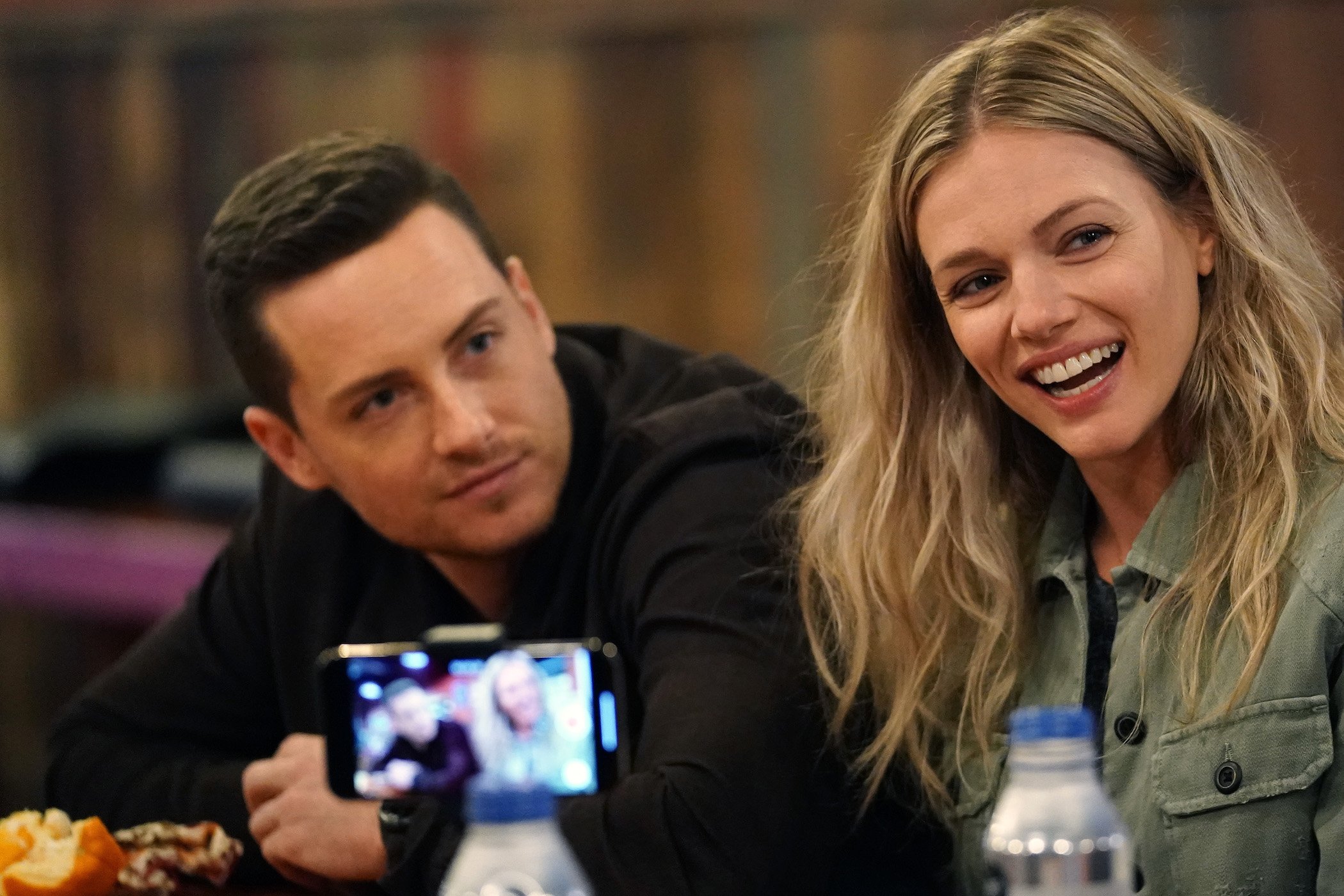 Jesse Lee Soffer and Tracy Spiridakos next to each other and talking at a 'Chicago P.D.' event.