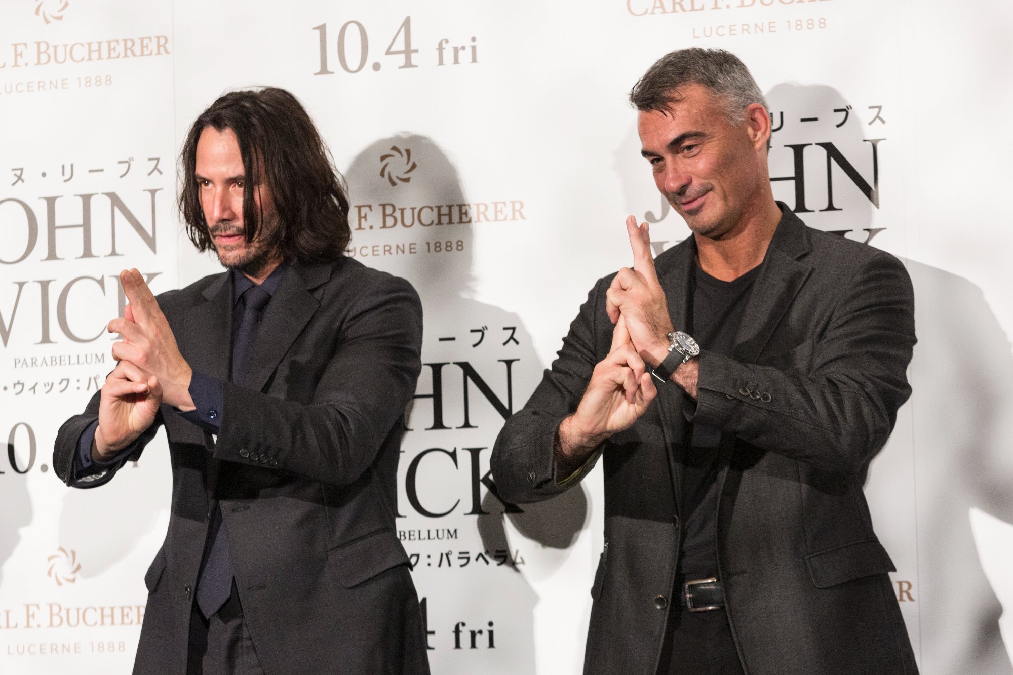 'John Wick 4' actor Keanu Reeves and director Chad Stahelski at the 'John Wick_ Chapter 3 - Parabellum' Japan premiere making hand signs in front of a step and repeat