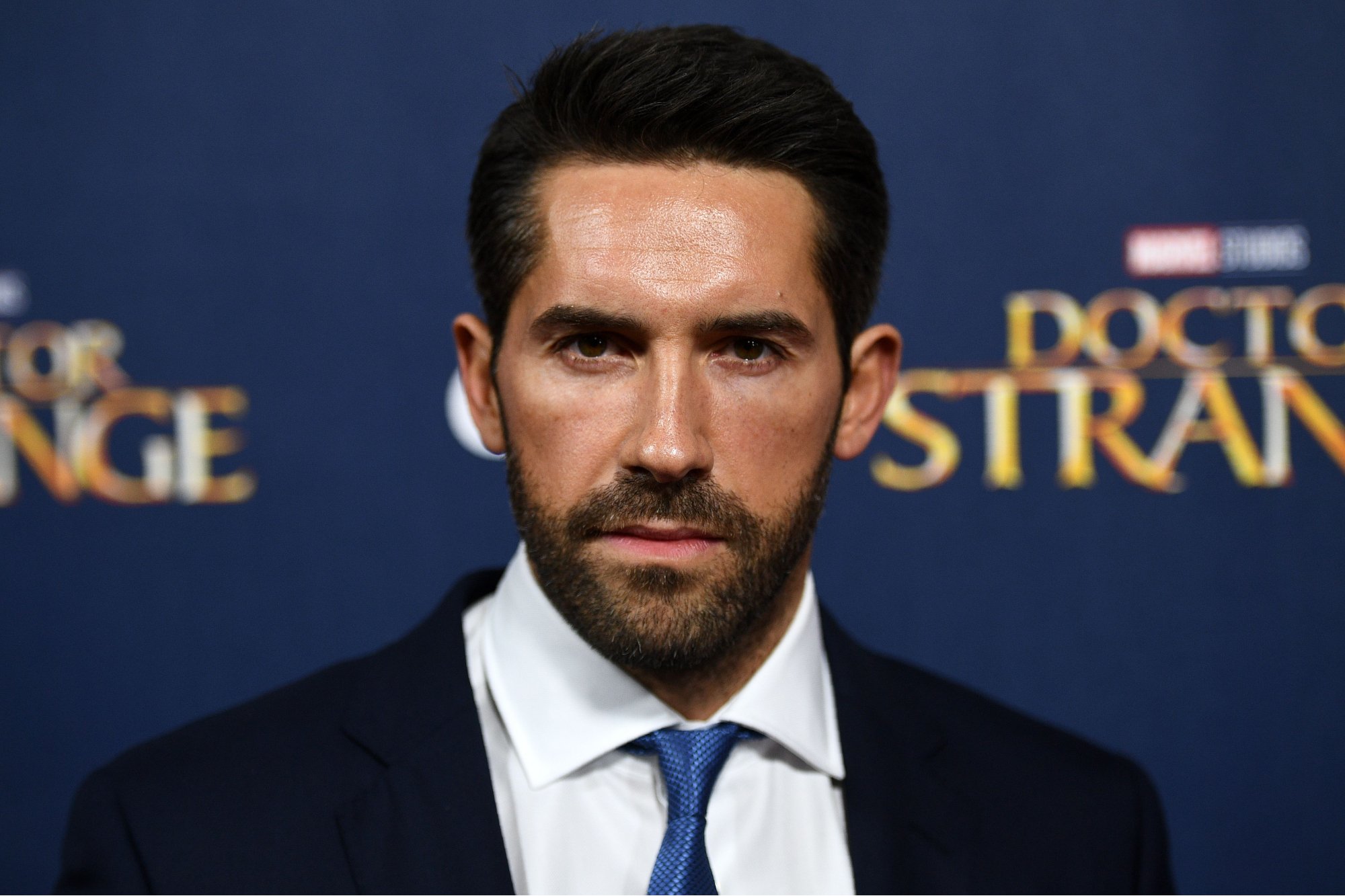 'John Wick 4' actor Scott Adkins at a launch event for 'Doctor Strange' wearing a suit in front of a step and repeat
