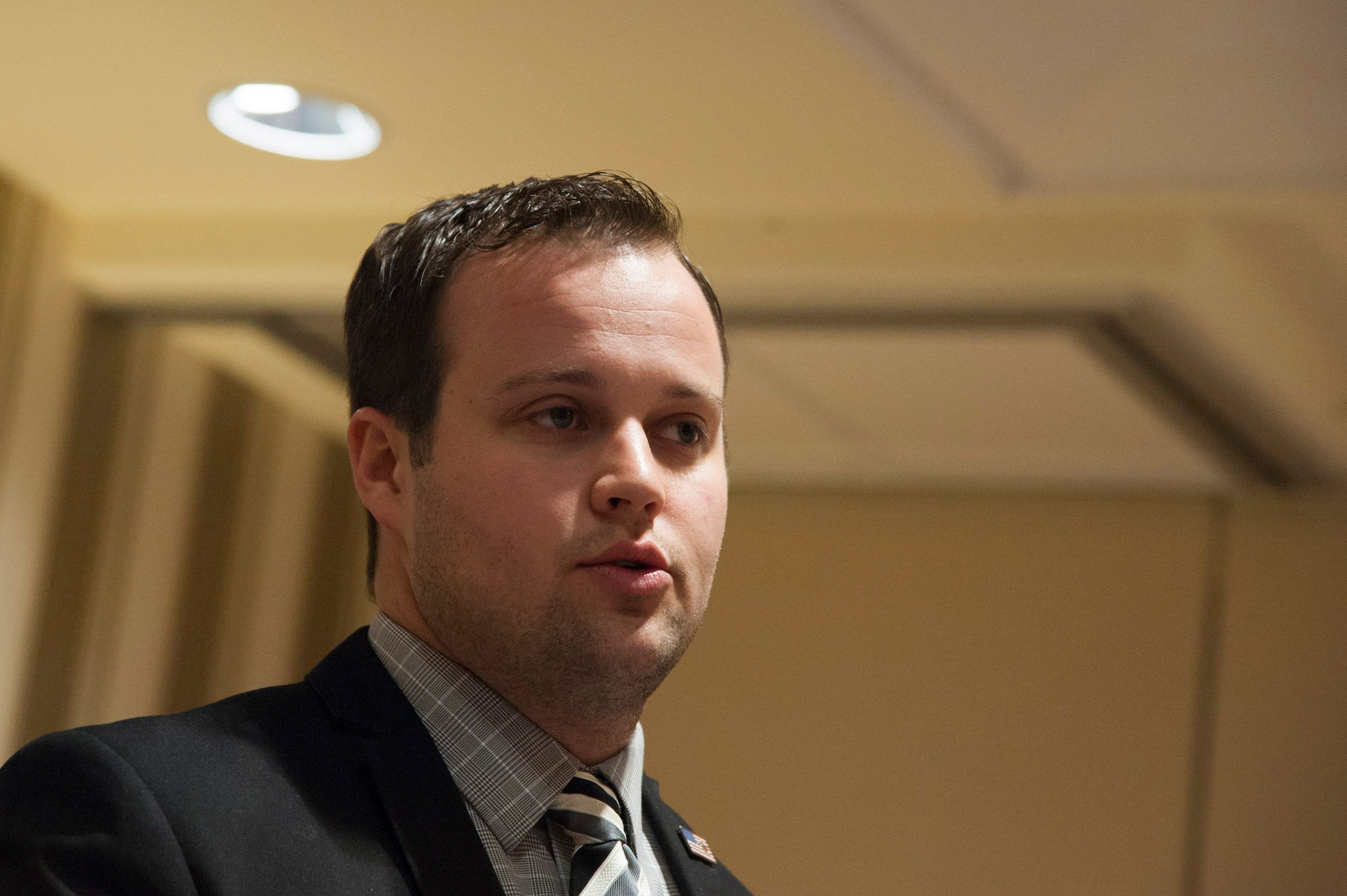 A close-up of Josh Duggar's face at a conference. Josh Duggar news notes Josh was arrested in April 2021 on suspicion of obtaining child sexual abuse material.