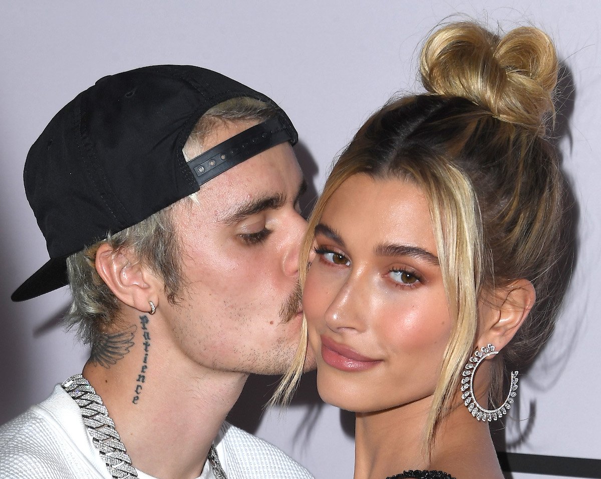 Justin Bieber kisses Hailey Bieber's cheek at an event.