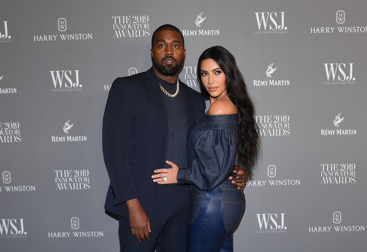 Kanye West and Kim Kardashian West pose together at an event.