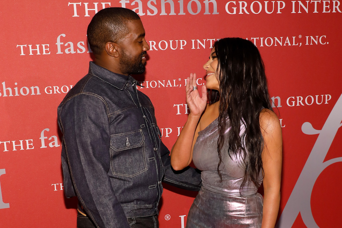 Kanye West and Kim Kardashian West smile at each other.