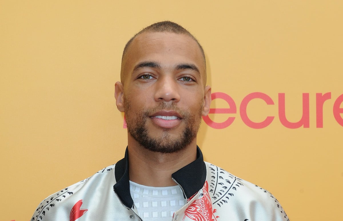 Kendrick Sampson wears a light-colored jacket with black and red designs at an event for the show 'Insecure'