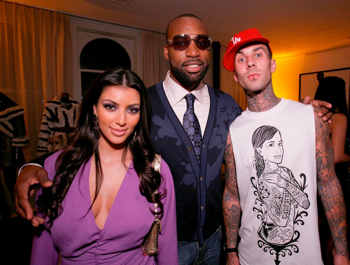 Kim Kardashian, Baron Davis, and Travis Barker pose together at an event.