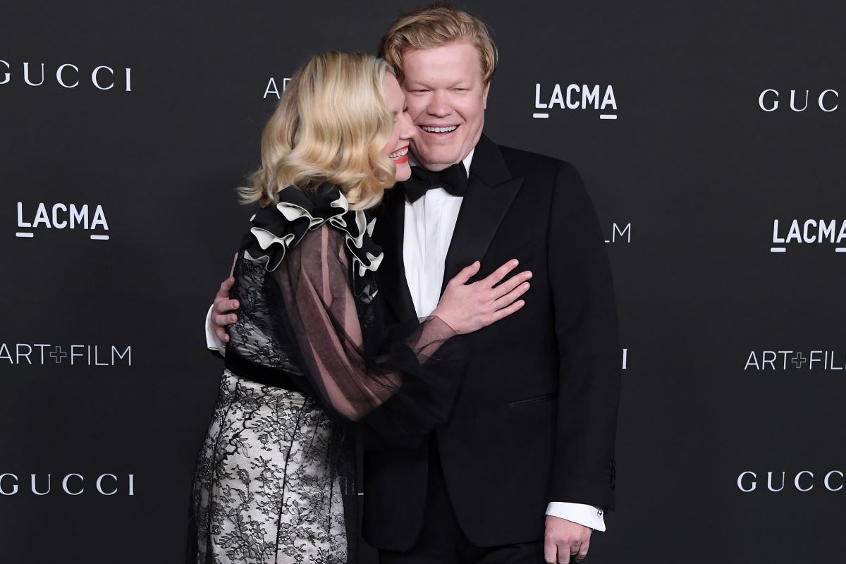 Kirsten Dunst and Jesse Plemons, both dressed in black formalwear and leaning in close to each other