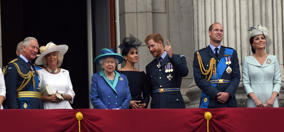 (L-R): Prince Charles, Camilla Parker Bowles, Queen Elizabeth ll, Meghan Markle, Prince Harry, Prince William, and Kate Middleton standing together on the balcony of Buckingham Palace to view a flypast