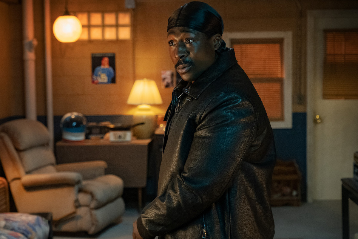 Eric Kofi-Abrefa as Lamar wearing a durag and black trench coat 'BMF'