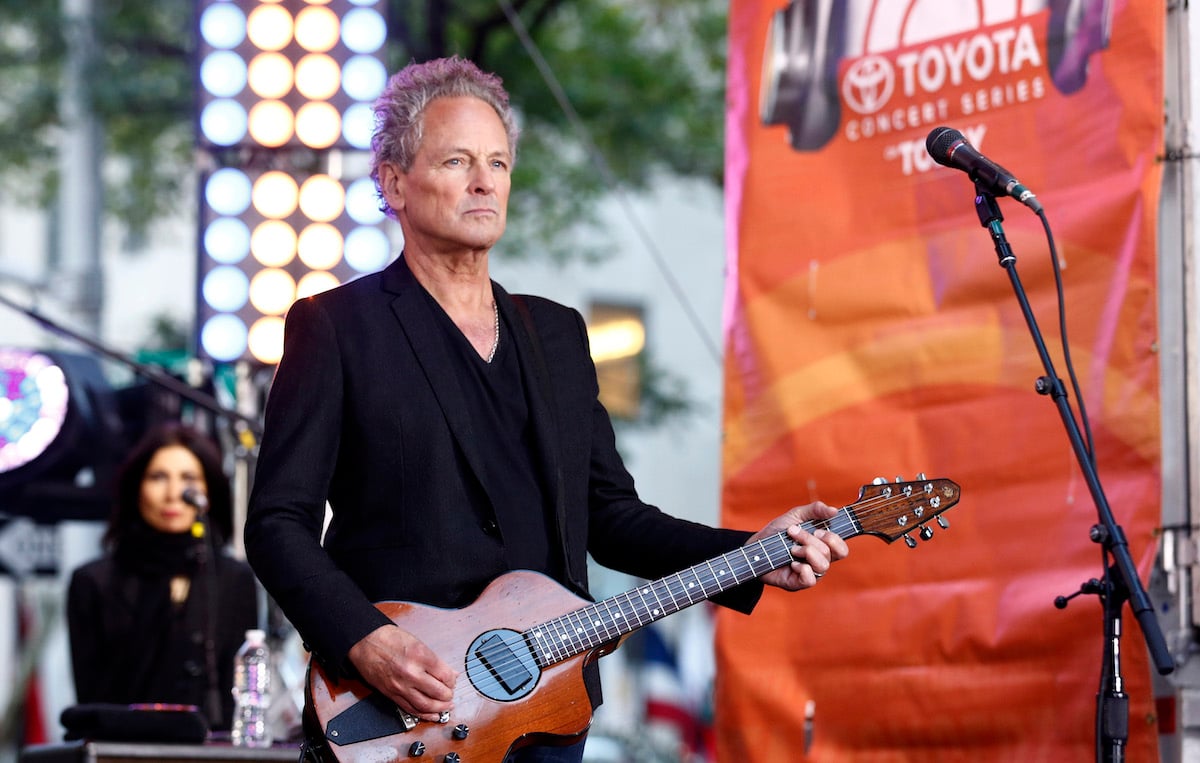 Lindsey Buckingham plays the guitar on stage.