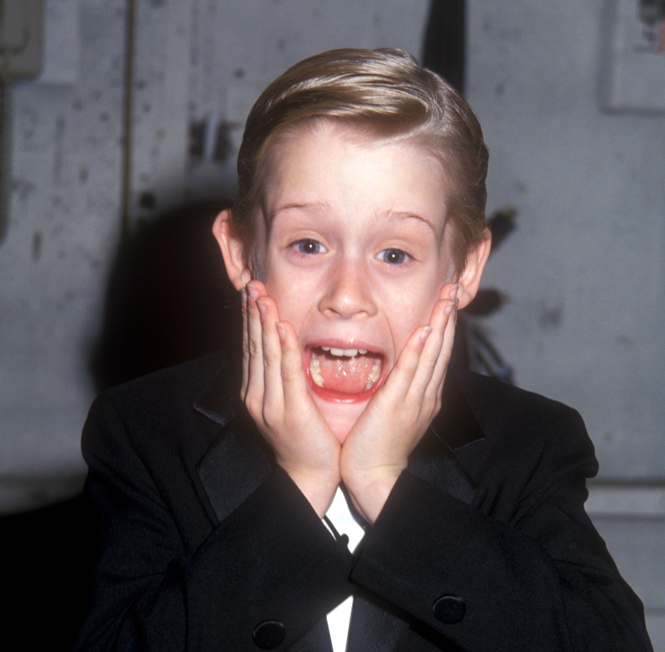 Macaulay Culkin putting his hands to his face at comedy award show in 1991