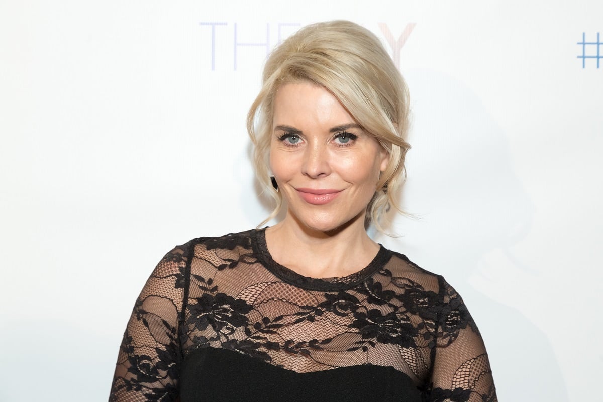 'Passions' actor McKenzie Westmore wearing a black dress and posing in front of a white backdrop.