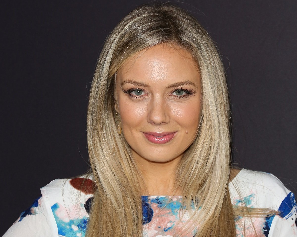 'The Young and the Restless' actor Melissa Ordway in a blue and white print dress posing in front of black backdrop.