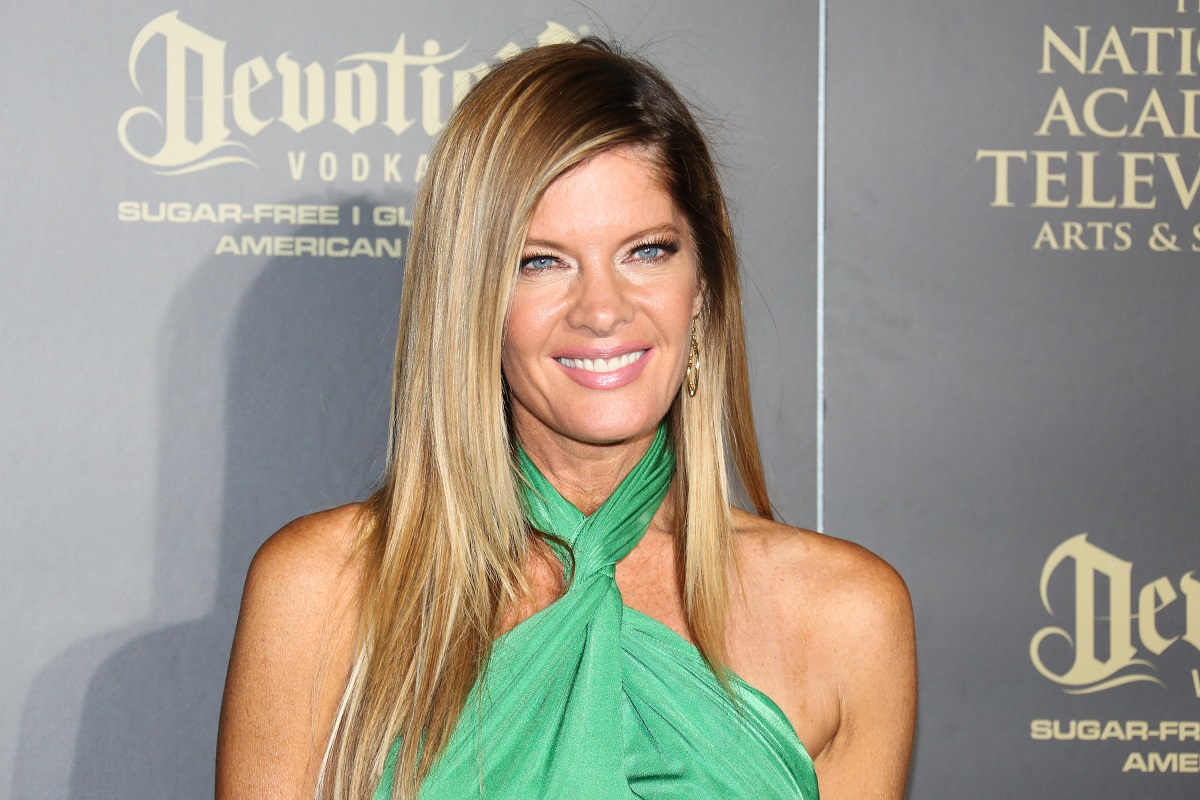 'The Young and the Restless' actor Michelle Stafford wearing a green dress and smiling for photographers.