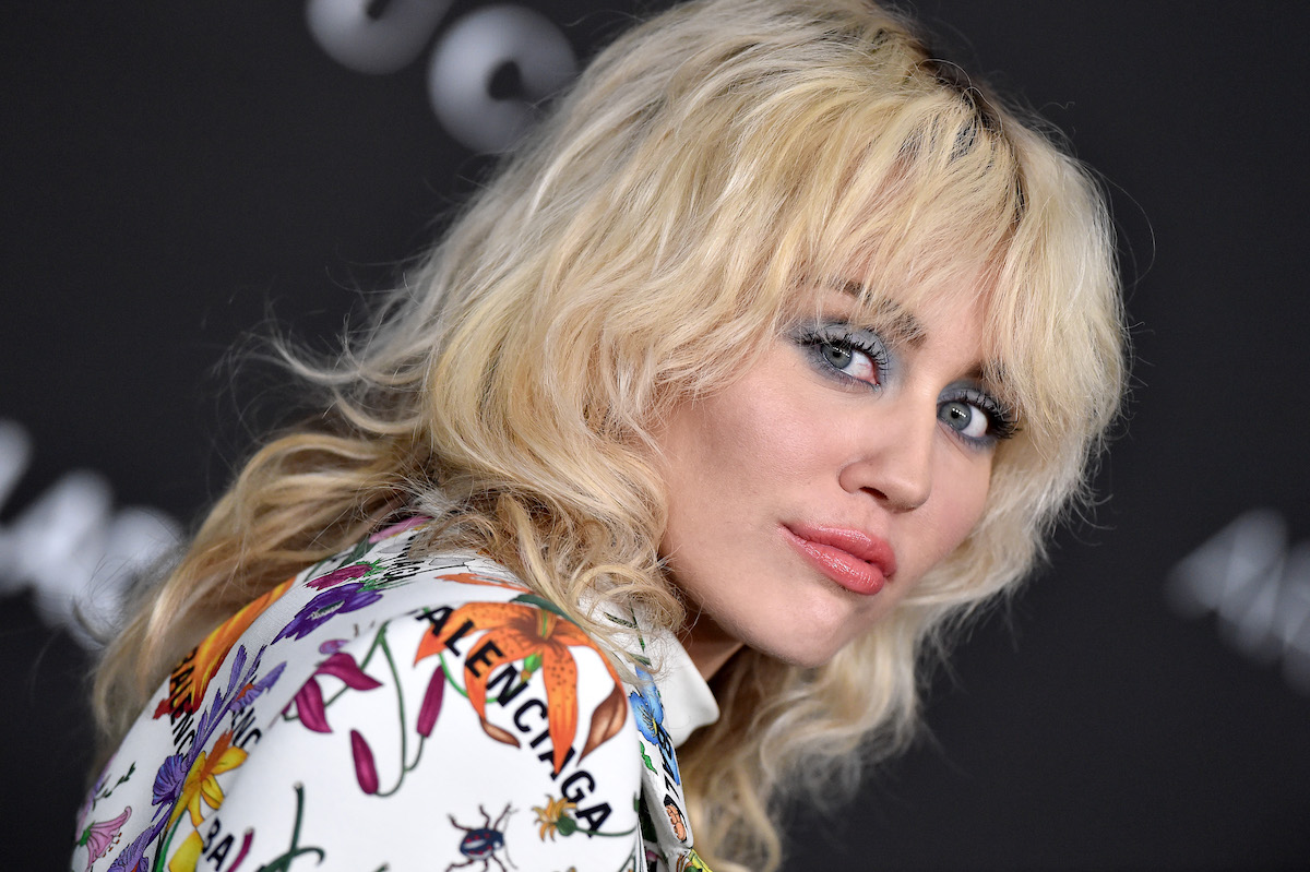 Miley Cyrus looks over her shoulder at the camera at an event.