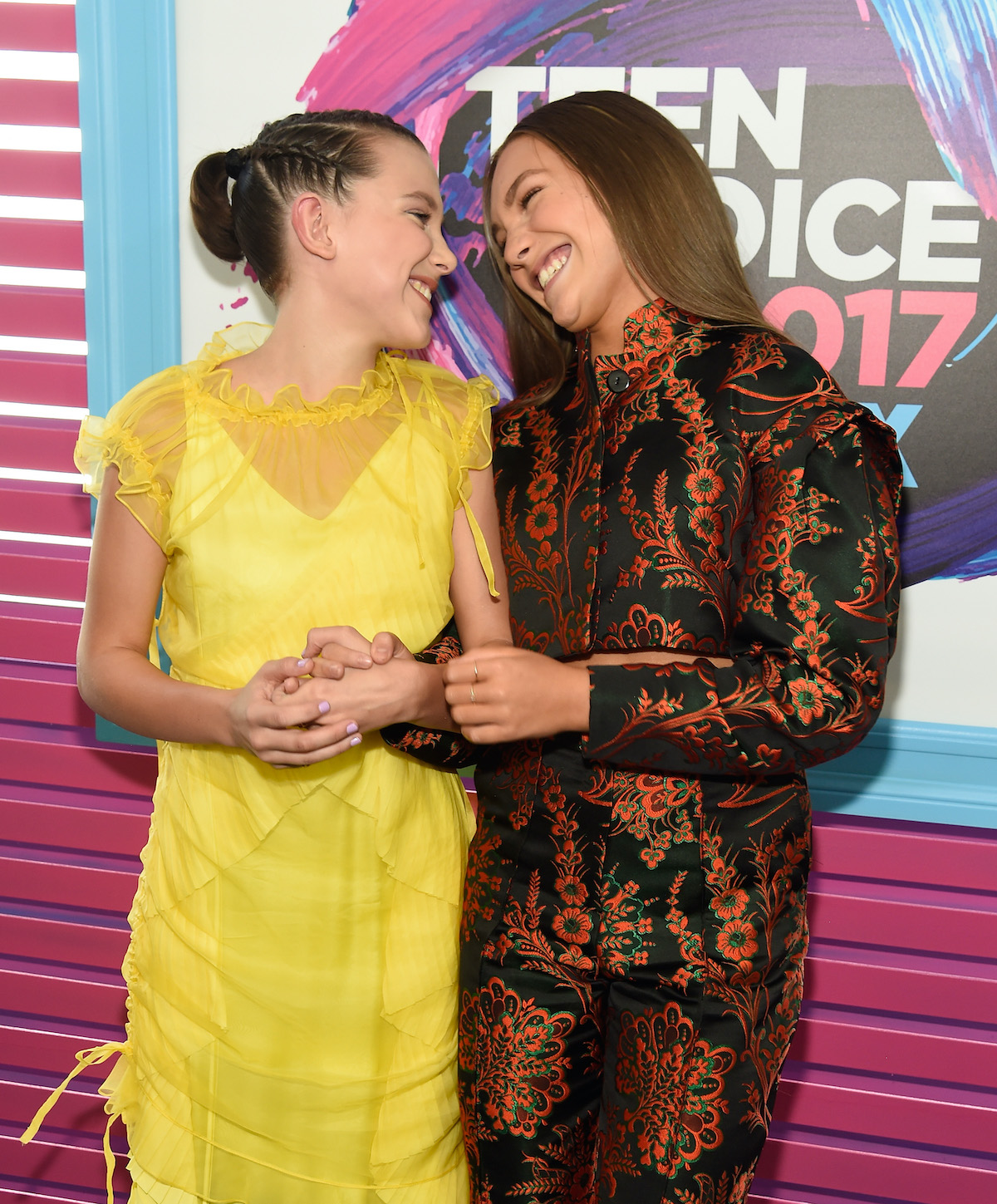 Millie Bobby Brown and Maddie Ziegler smile at each other on the red carpet