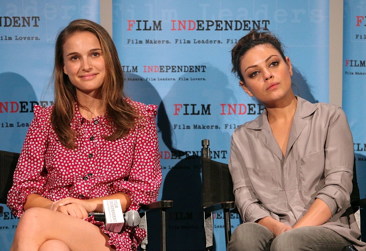 Natalie Portman sitting next to Mila Kunis smiling