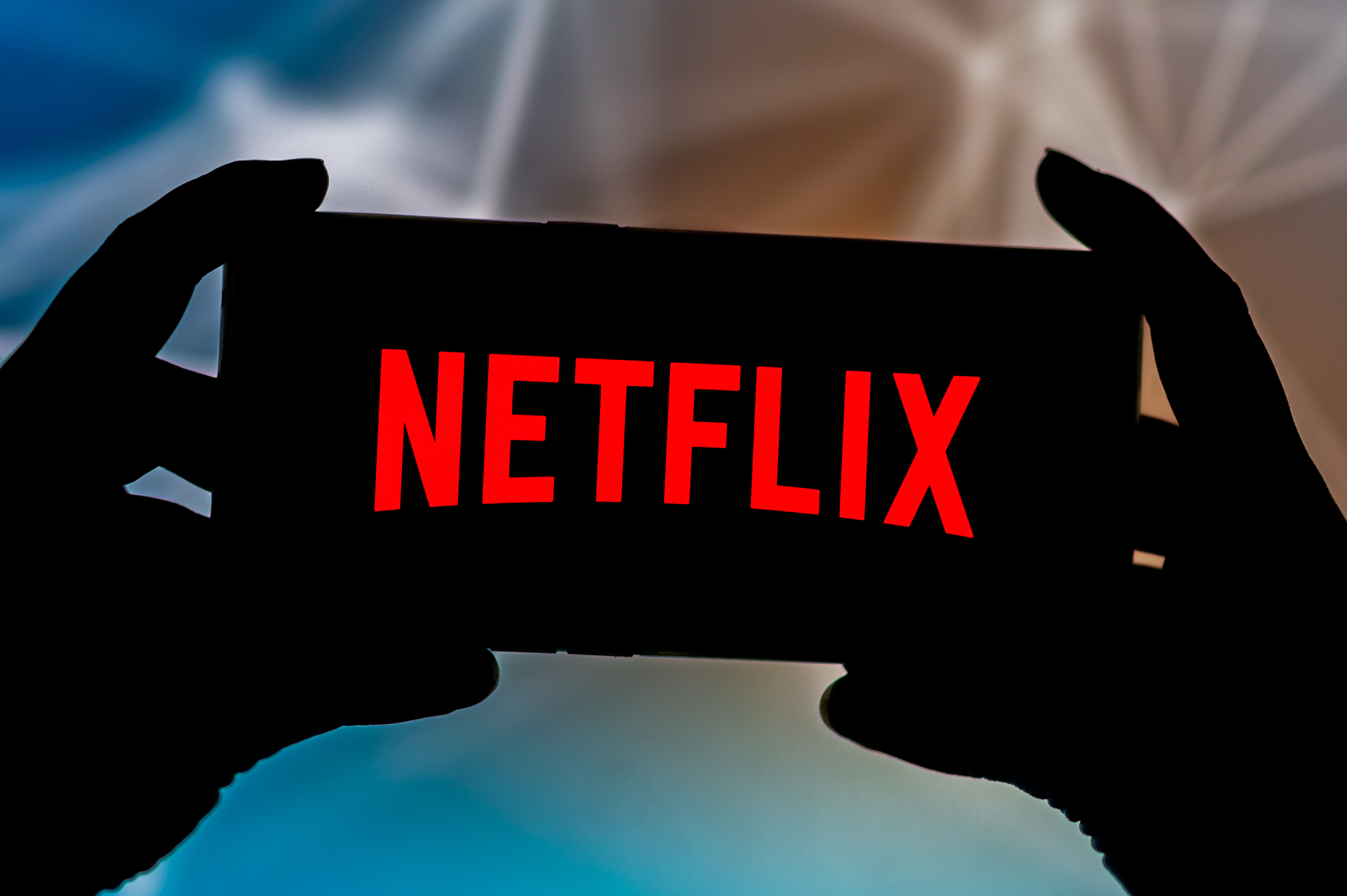 The Netflix logo seen displayed on a smartphone. Netflix shipped its first DVD in 1998