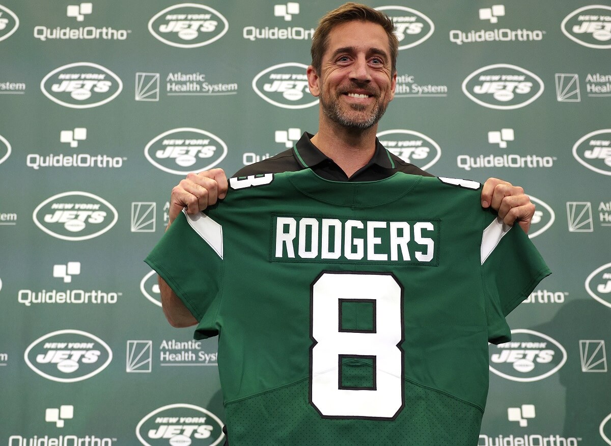 New York Jets quarterback Aaron Rodgers poses with a jersey during an introductory press conference