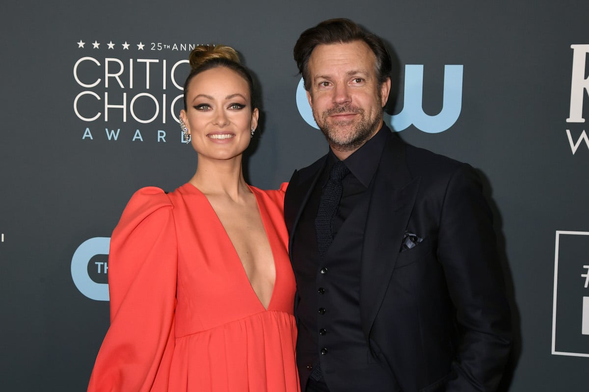 Olivia Wilde and Jason Sudeikis smile and pose together at an event.