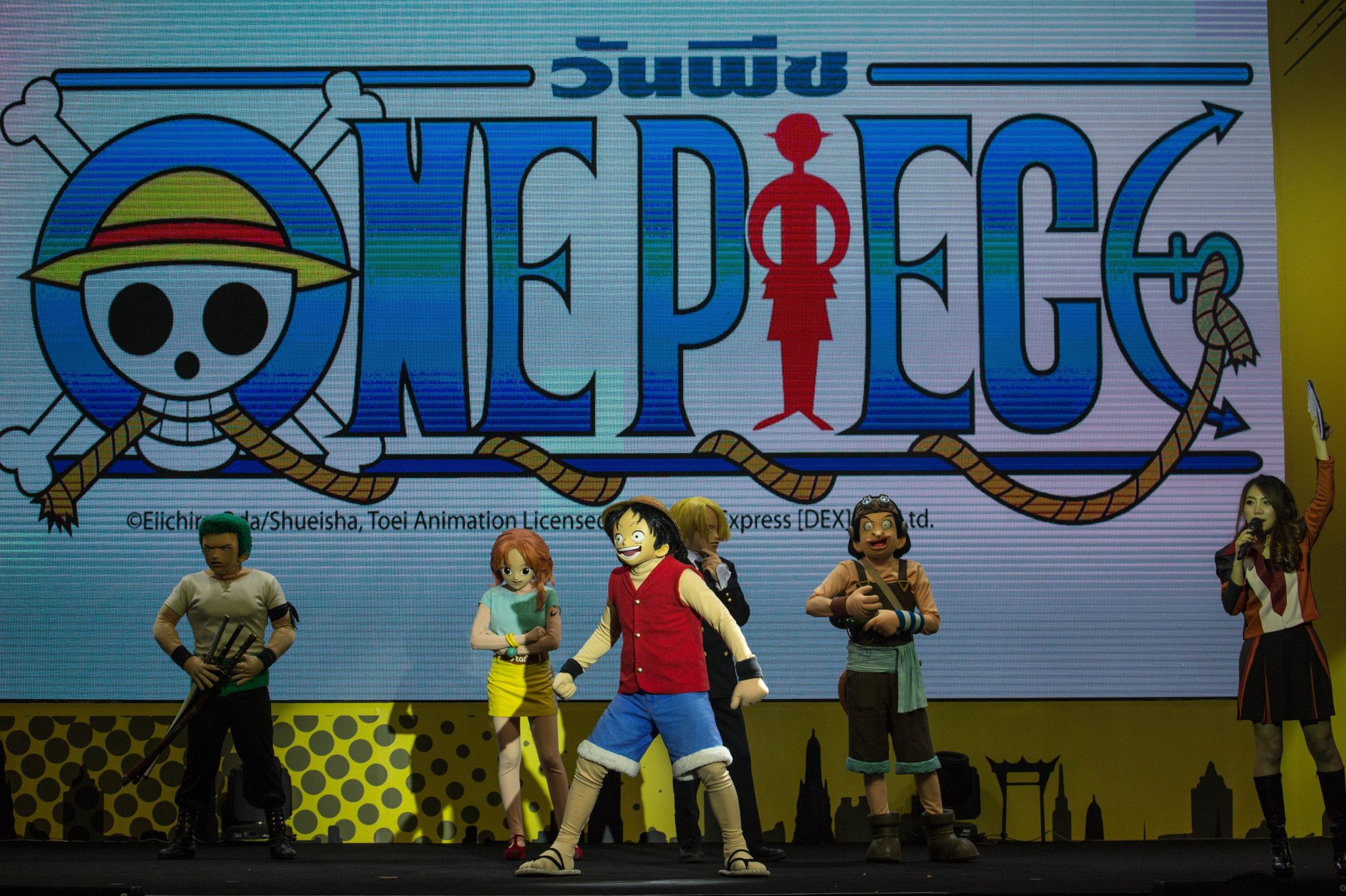 'One Piece' anime logo and cosplayers of Luffy D. Monkey and the Straw Hats.