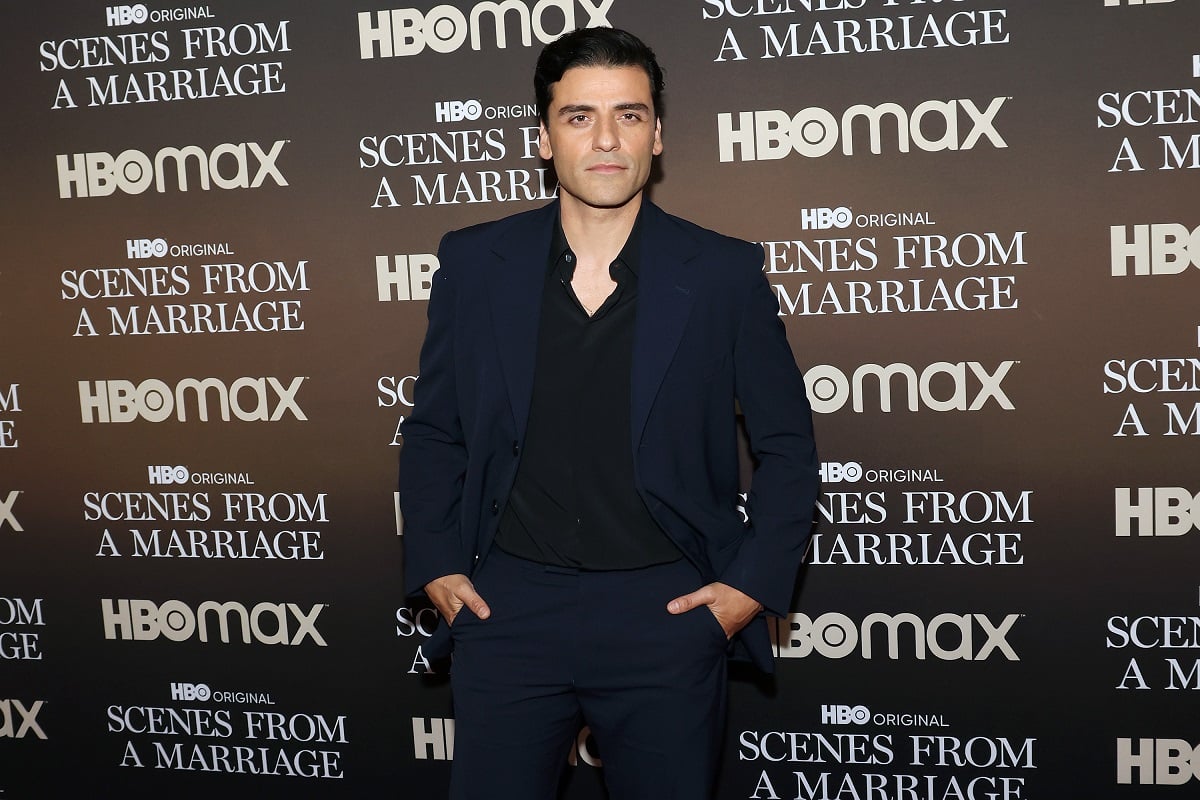 Oscar Isaac posing in a suit