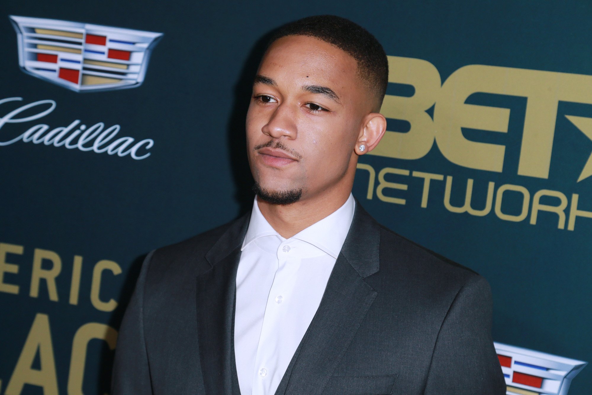 Peyton Alex Smith wearing a black suit with a white shirt to the 2018 American Black Film Festival Honors Awards.