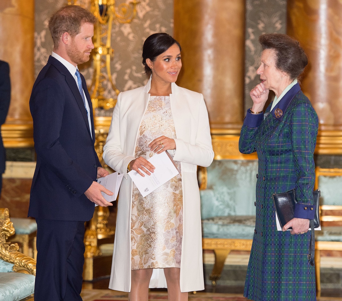 Prince Harry, Meghan Markle, and Princess Anne having a conversation during a reception at Buckingham Palace