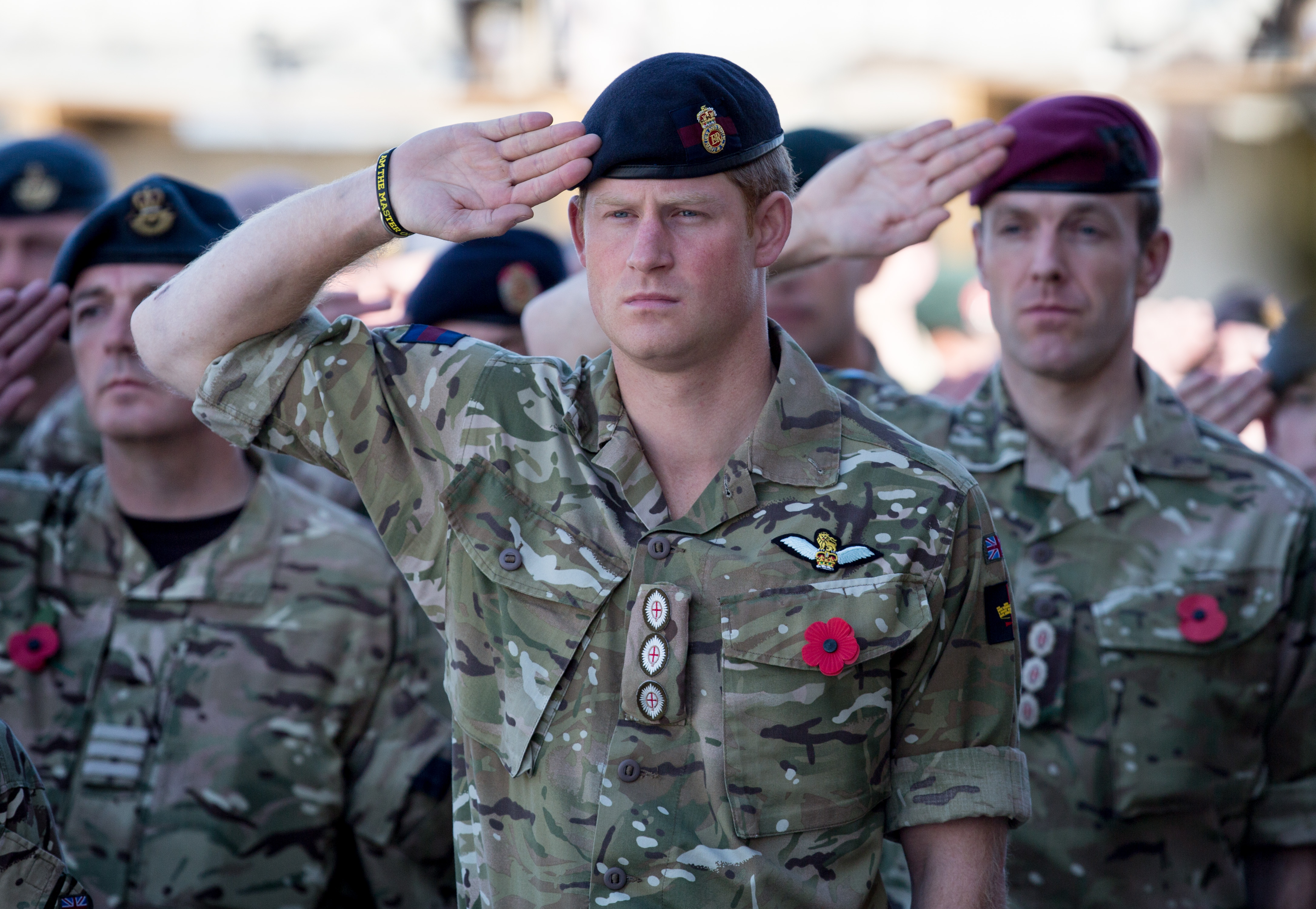 Prince Harry in uniform along with other British troops saluting on Remembrance Day