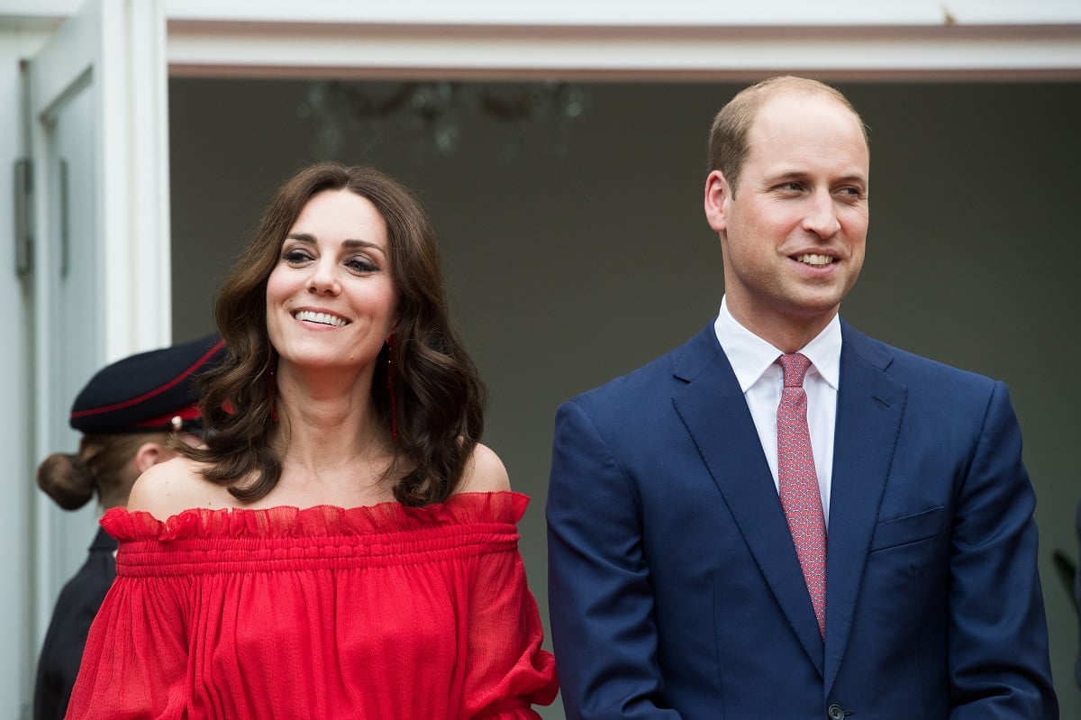 Prince William in a navy suit and Kate Middleton in a red off-the-shoulder outfit as they attend the queen's birthday party