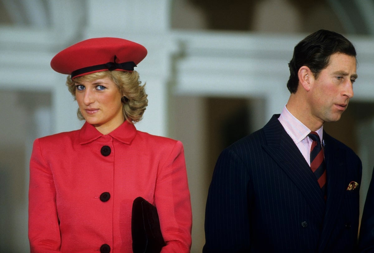 Princess Diana dressed in red and Prince Charles in a navy suit during a function Germany