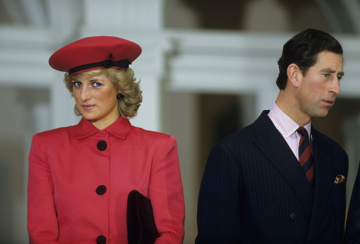 Princess Diana dressed in red and Prince Charles in a navy suit during a function Germany