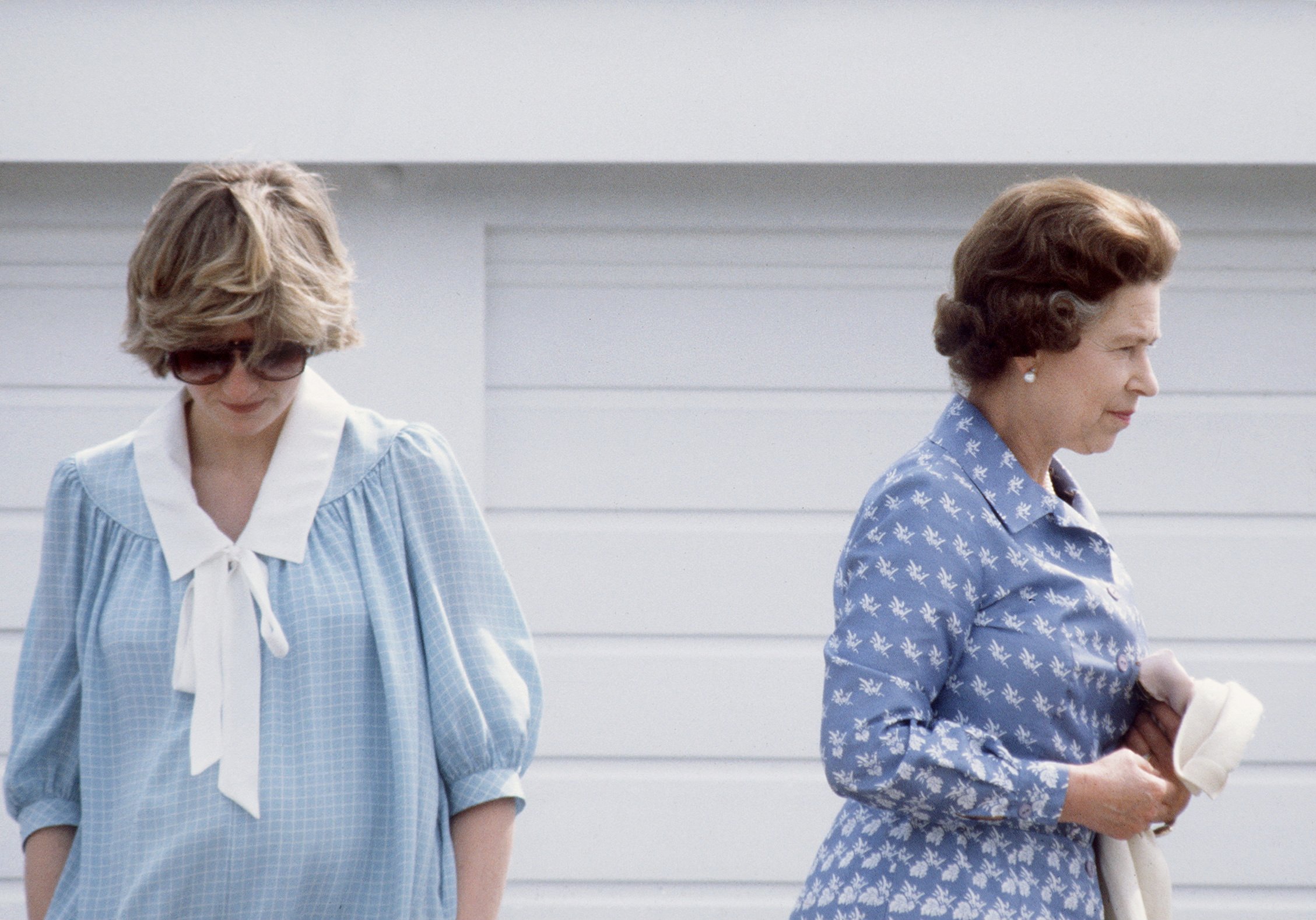 Princess Diana looking down at a polo match with Queen Elizabeth II in 1982