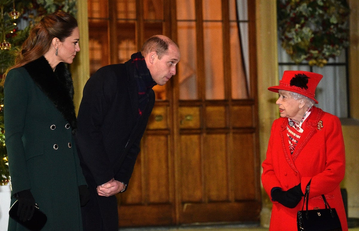 Queen Elizabeth II talks with Prince William and Kate Middleton as they wait to thank local volunteers outside Windsor Castle