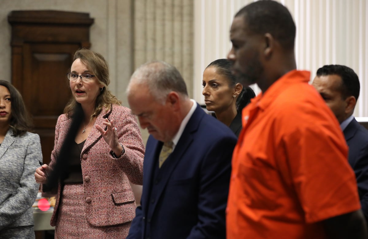 R. Kelly wearing an orange jumpsuits listens during a court hearing.