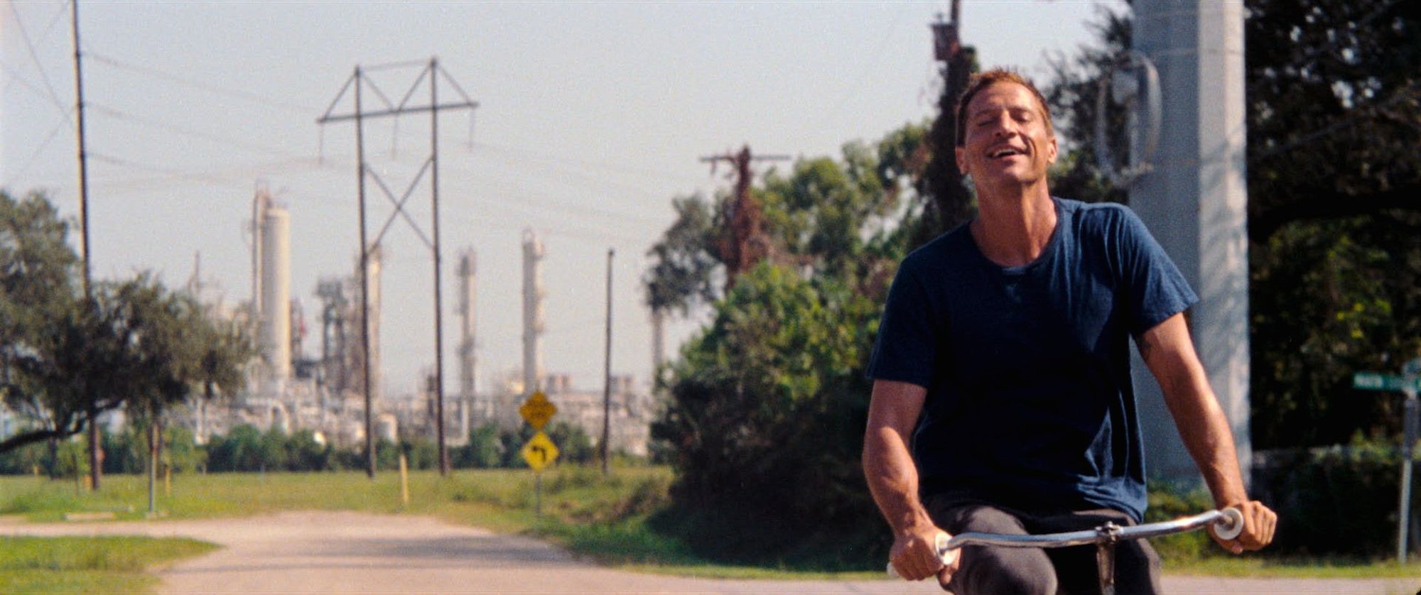 'Red Rocket' actor Simon Rex as Mikey smiling as he's riding his bike outside