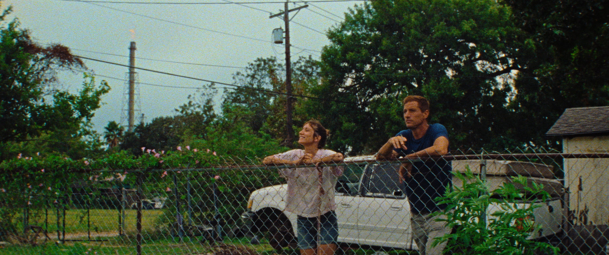 'Red Rocket' actors Bree Elrod as Lexi and Simon Rex as Mikey smoking cigarettes leaning on a fence outside