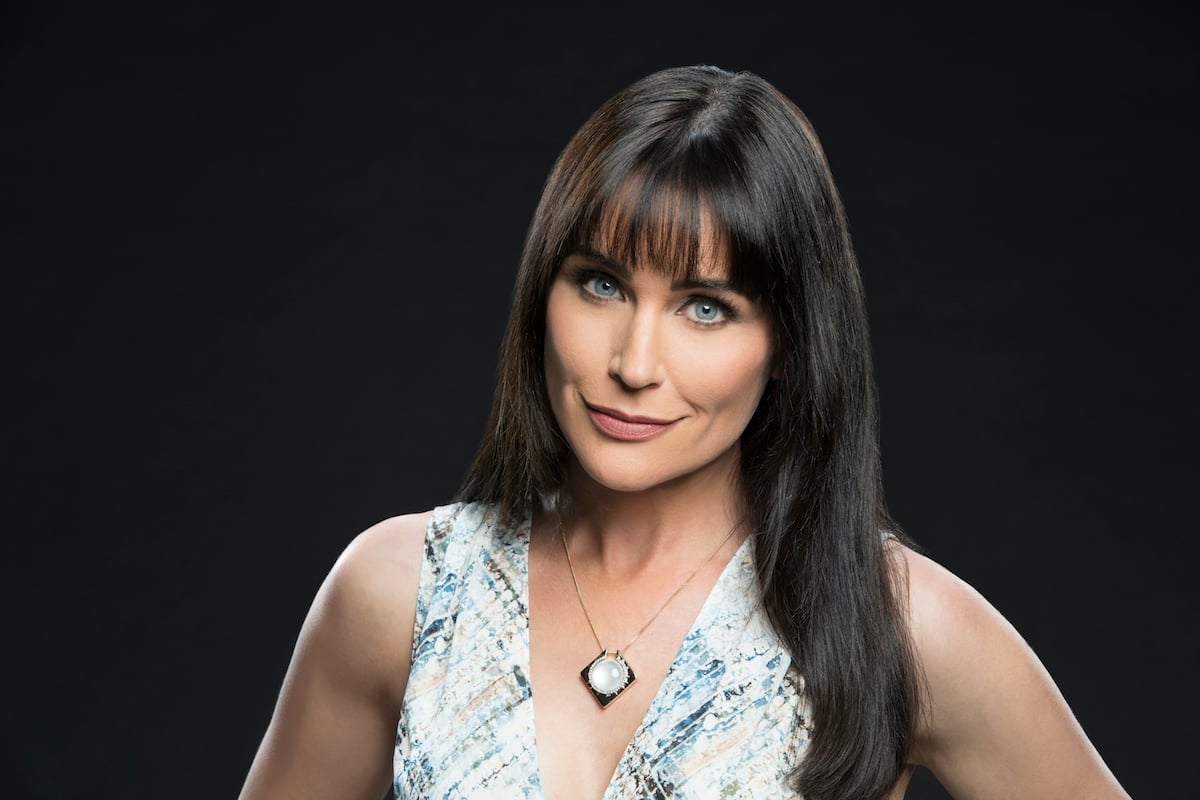 Rena Sofer smiling in front of a black background