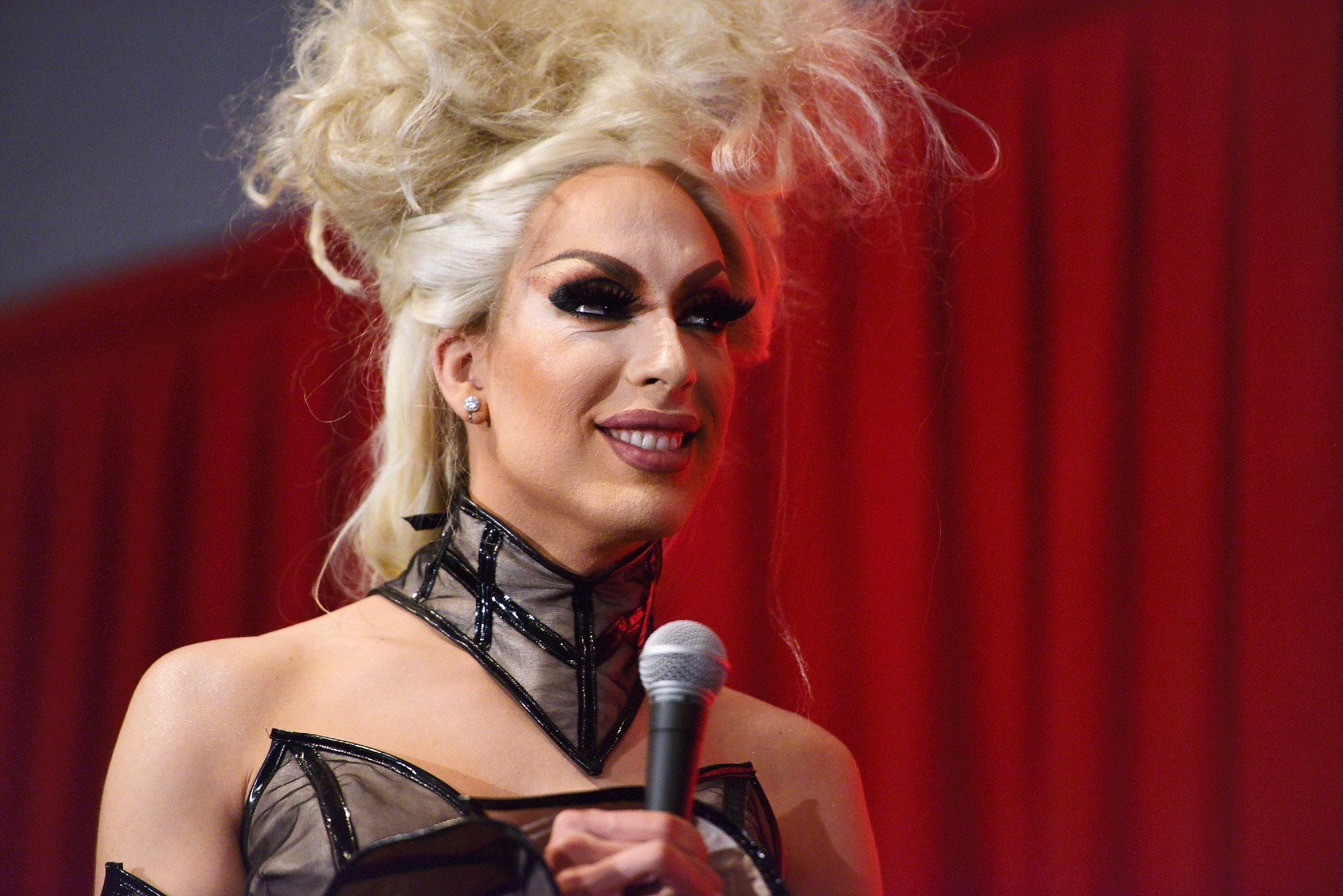 'RuPaul's Drag Race' Season 5 and All Stars 2 contestant Alaska on RuPaul smiling with blonde hair and a mic in hand