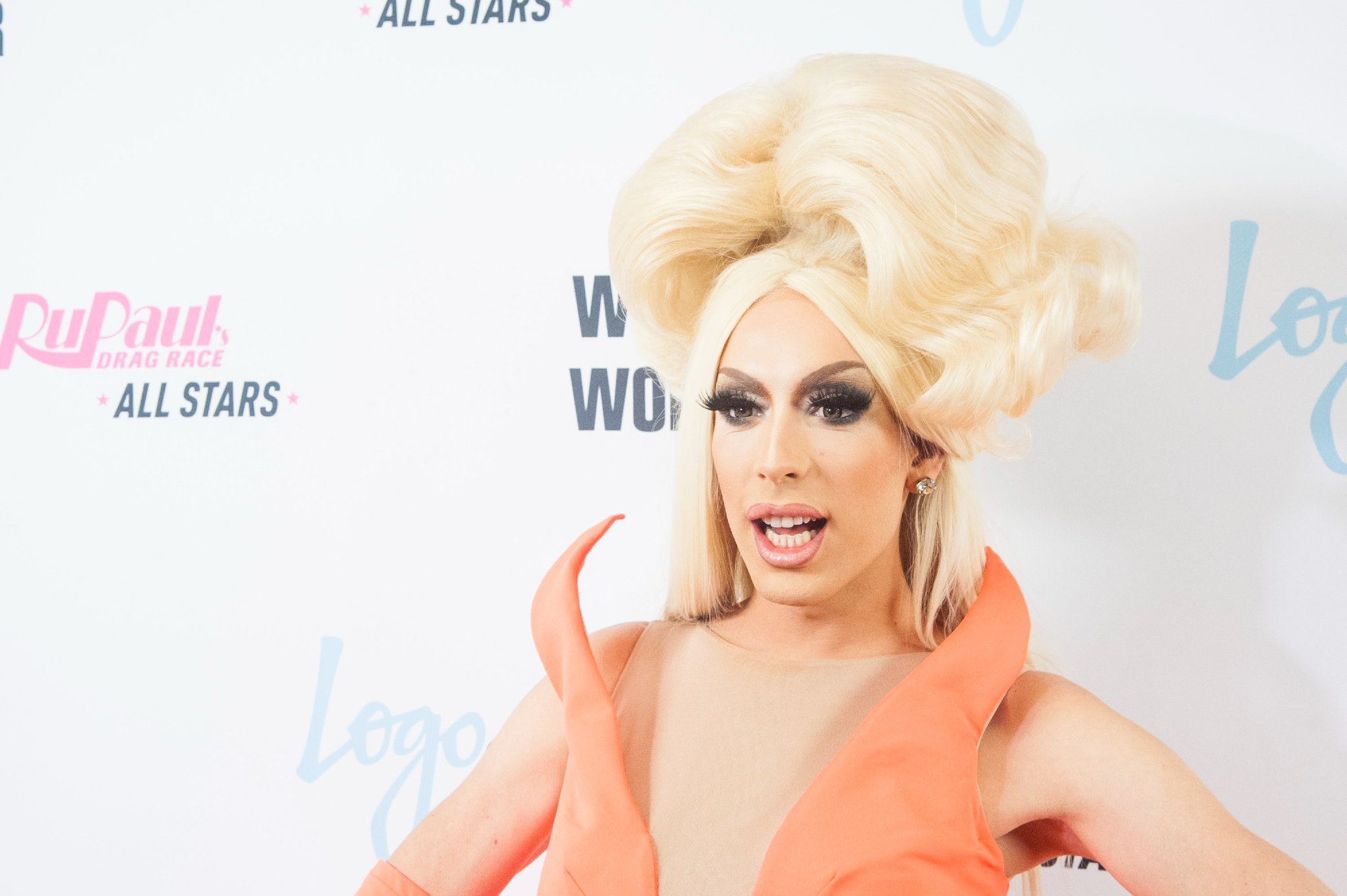 'RuPaul's Drag Race' Snatch Game winner Alaska smiling in a blonde wig and orange dress